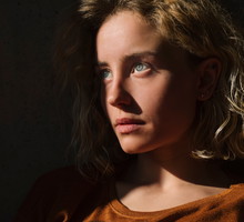 Portrait of pensive student with book looking at distance