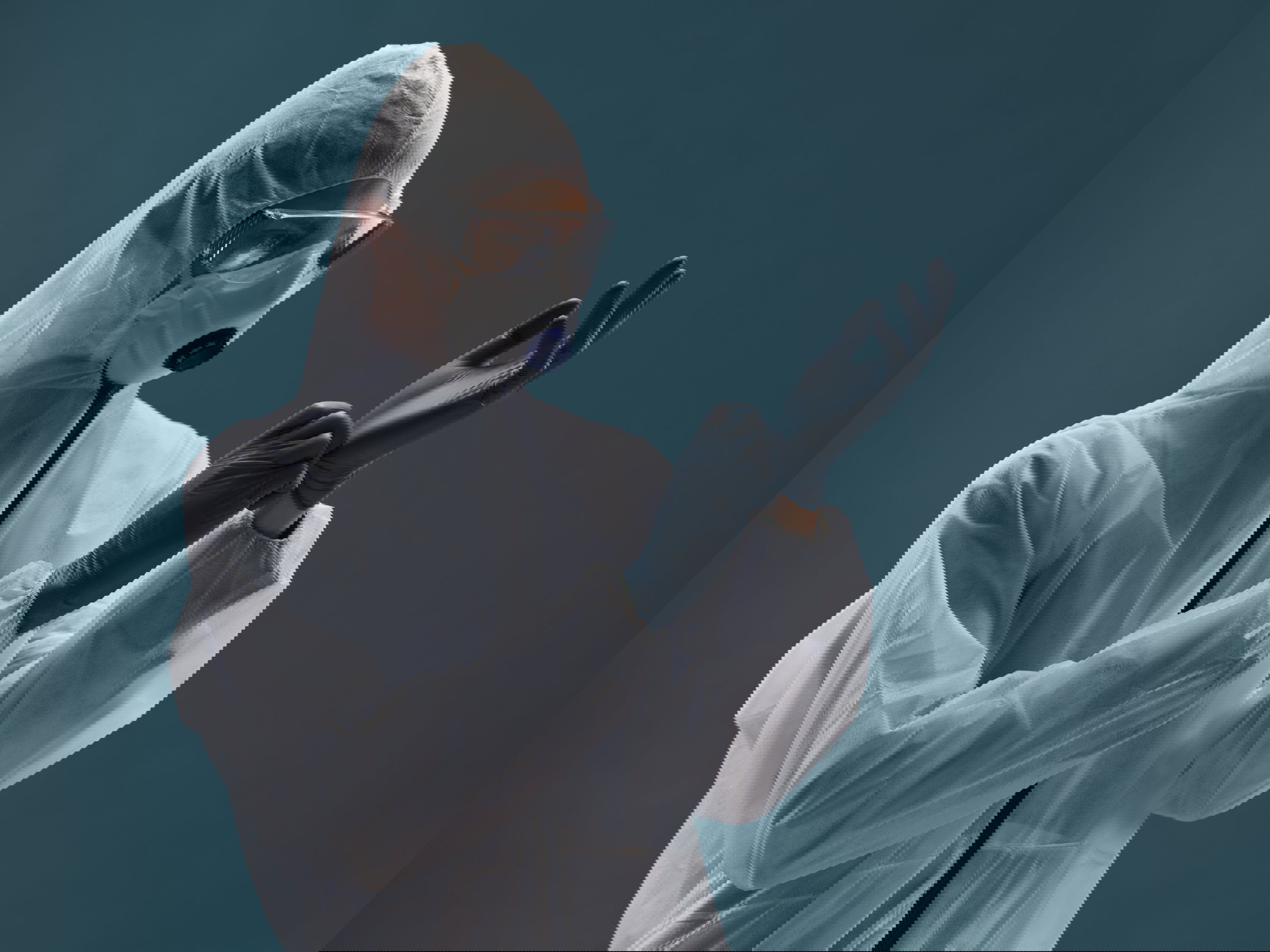 A medical professional in an antiplague suit is fully protected from the virus and wear sterile rubber gloves.