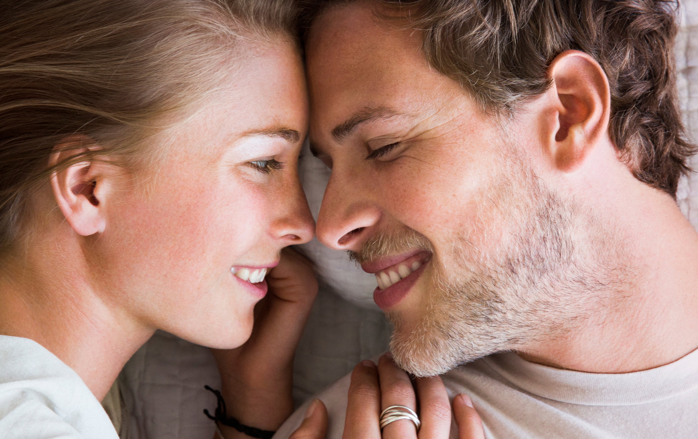 Young couple touching noses in bed