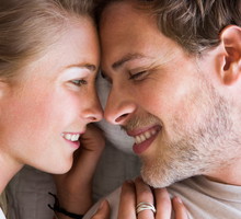 Young couple touching noses in bed