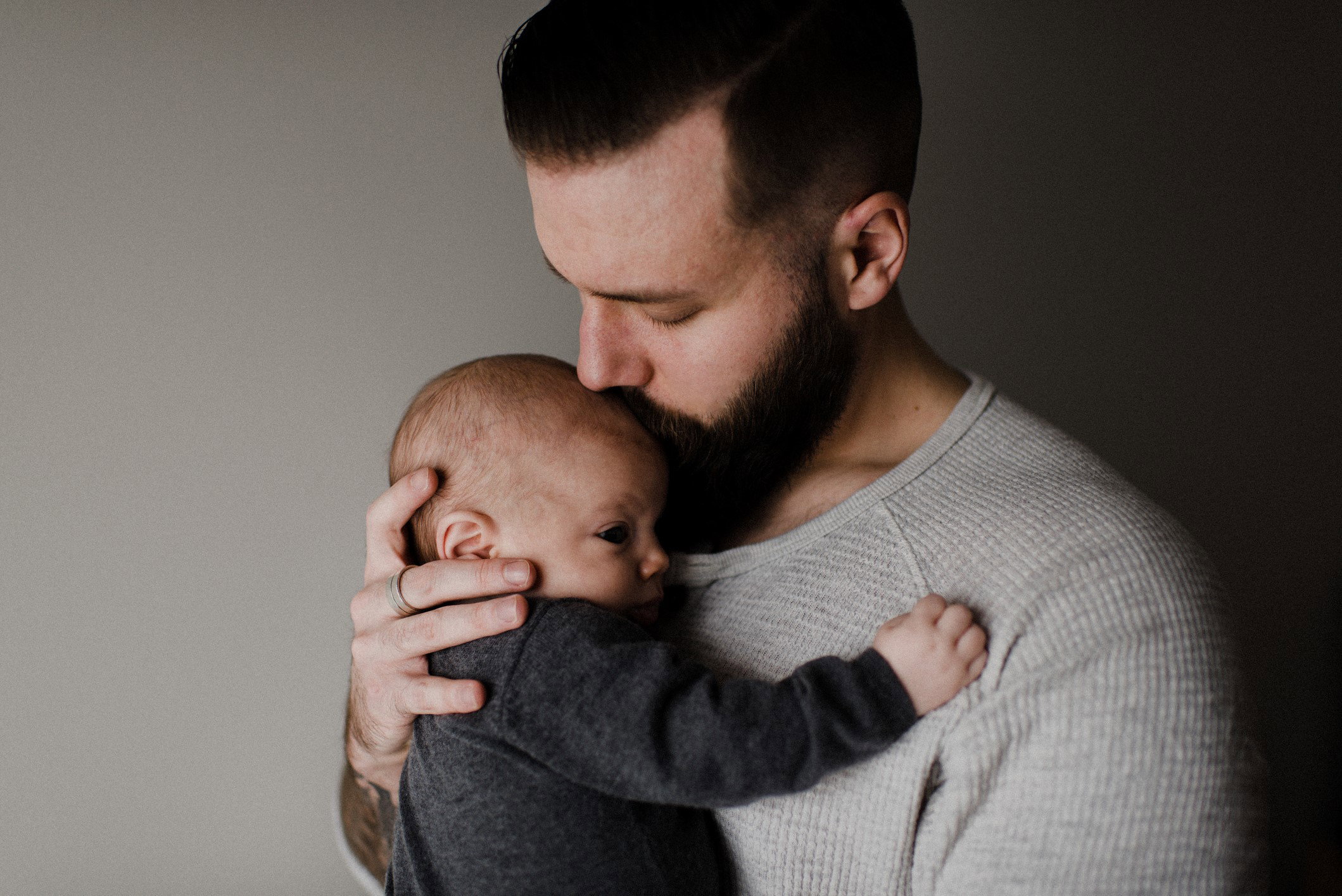 Young man kissing baby son on head, head and shoulders