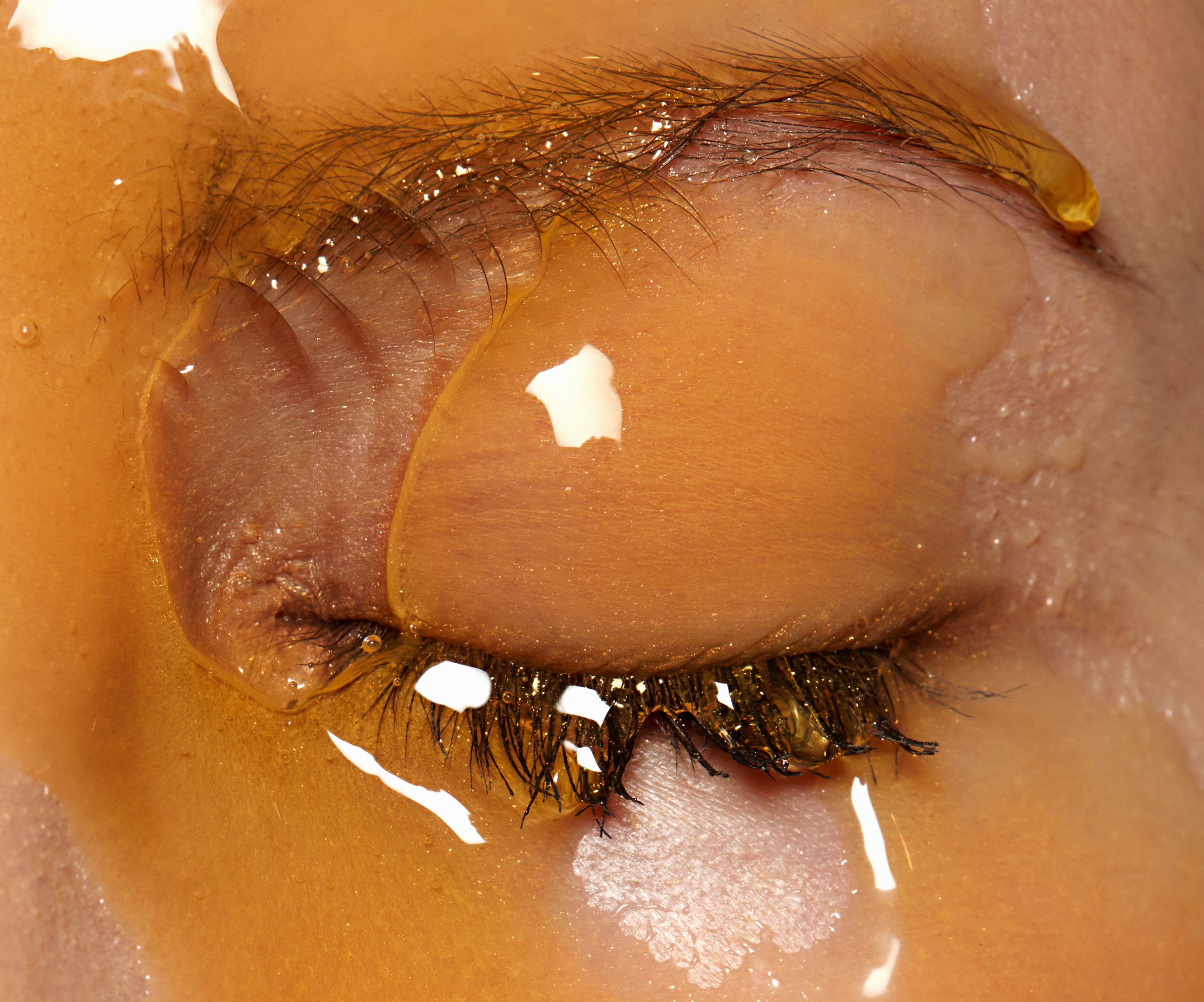 Female models face covered in honey