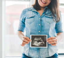 Woman with pregnancy scan in her hand.