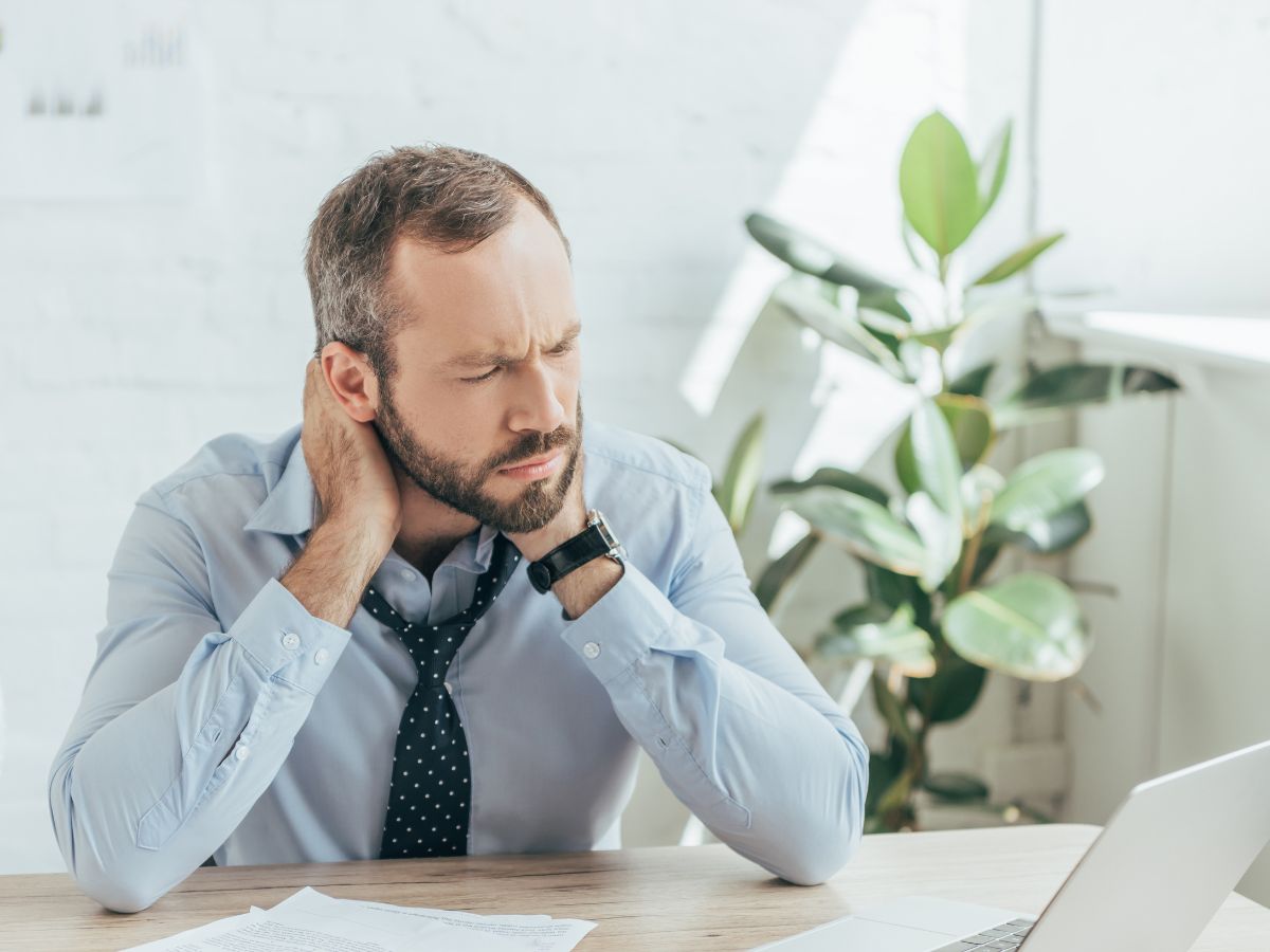 Mężczyzna przy komputerze z fikusem