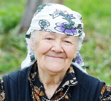 Very aged woman sitting in nature, portrait