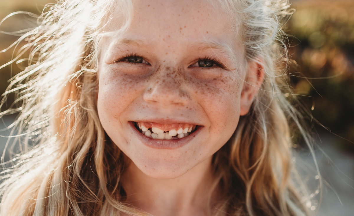 Close up Portrait of young school age girl with freckles smiling