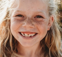 Close up Portrait of young school age girl with freckles smiling