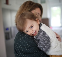 A mum hugging her 1 year old baby boy in the kitchen