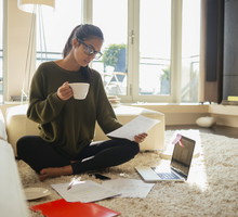 young woman reading paperwork in her living room,