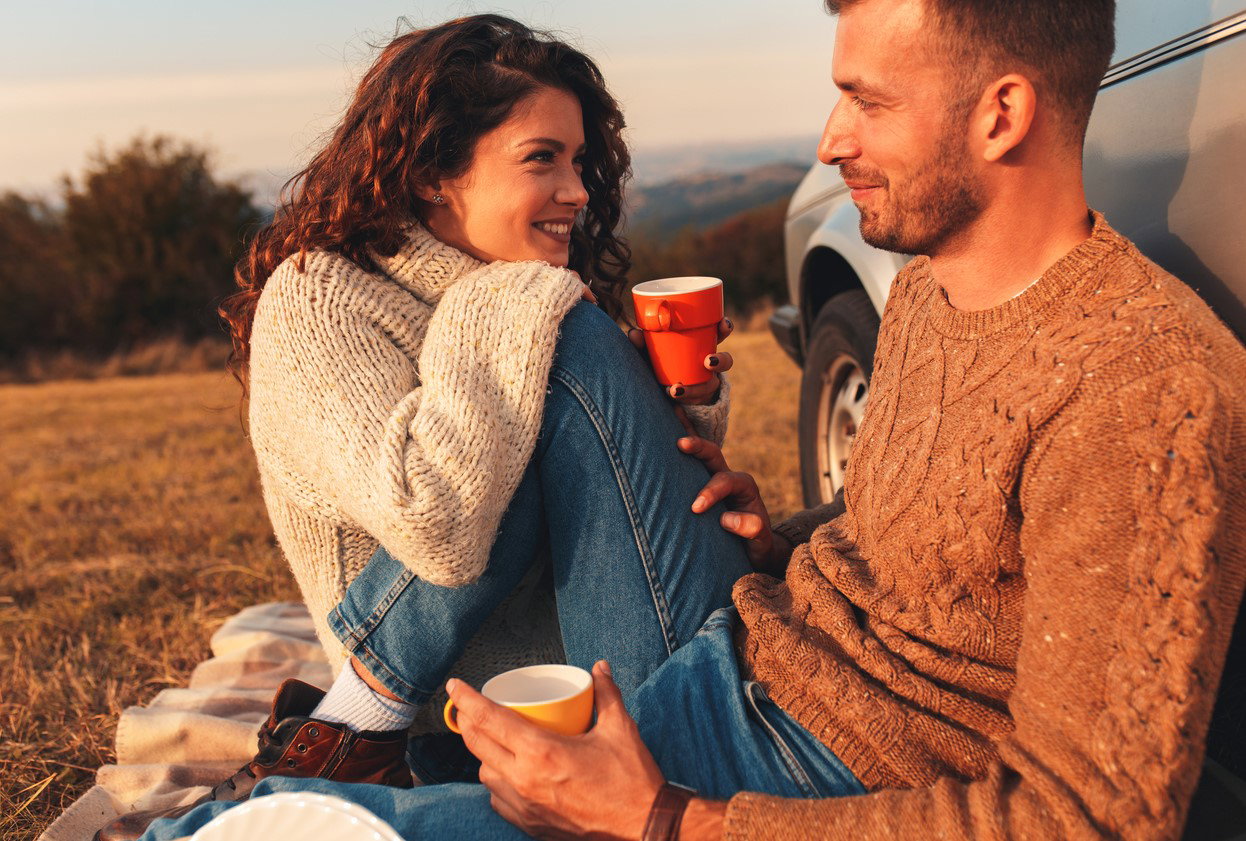 Beautiful young couple enjoying picnic time on the sunset.