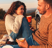 Beautiful young couple enjoying picnic time on the sunset.