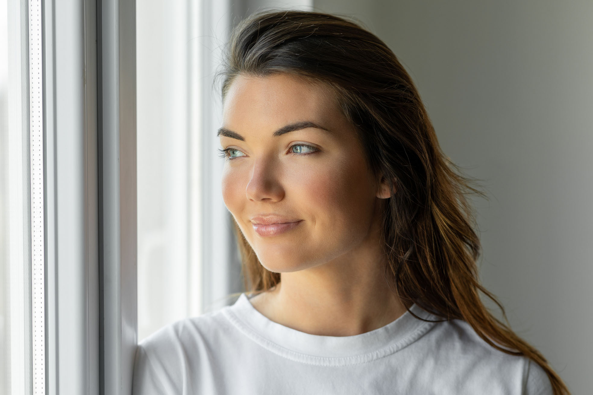 Woman looking through a house window