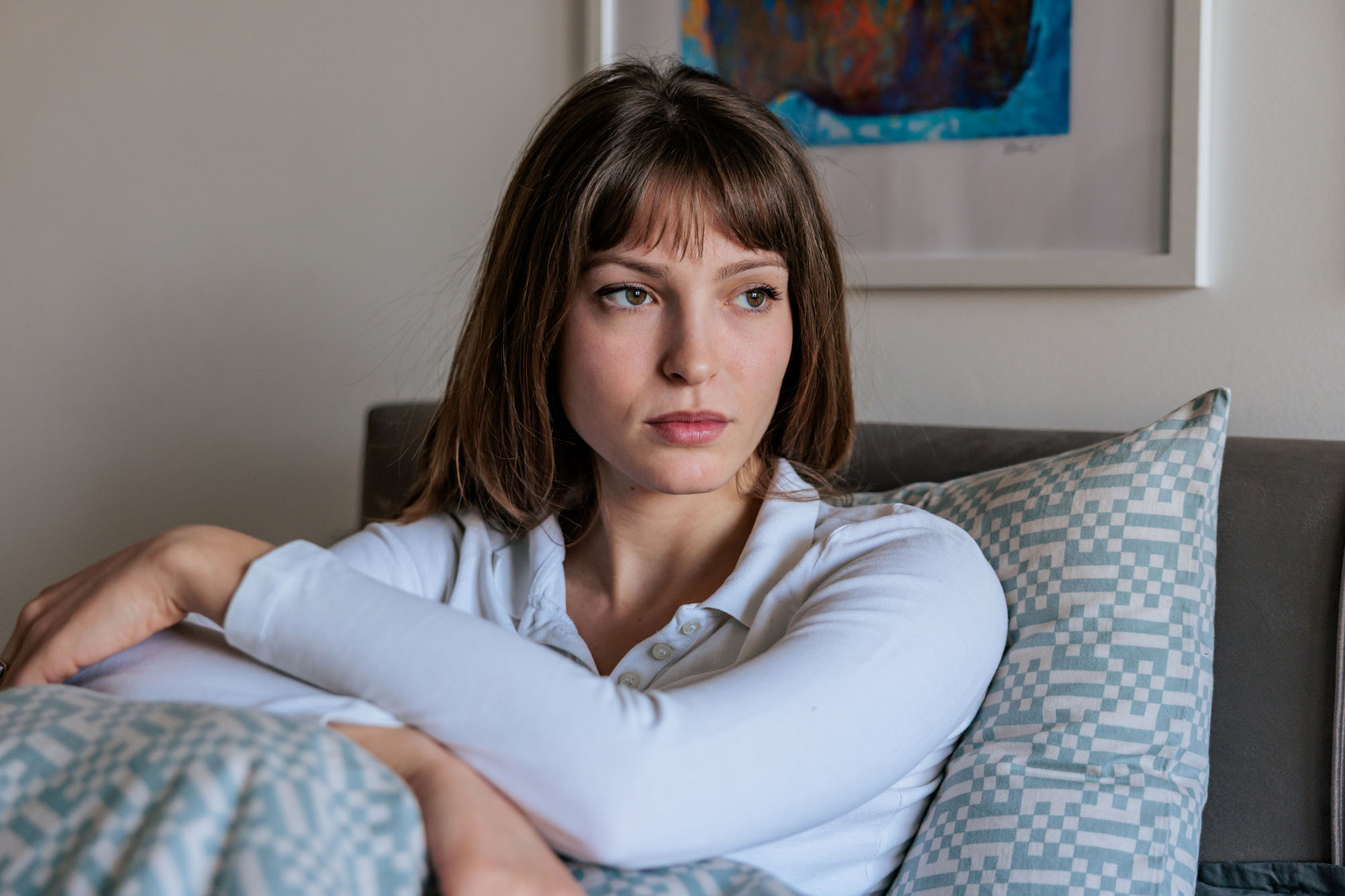 Young Woman Sitting Thoughtfully In Bed
