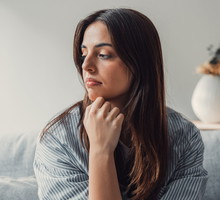 Close up of sad pensive millennial woman sit alone thinking about relationships personal problems, upset thoughtful young female lost in thoughts feel lonely depressed pondering or mourning at home