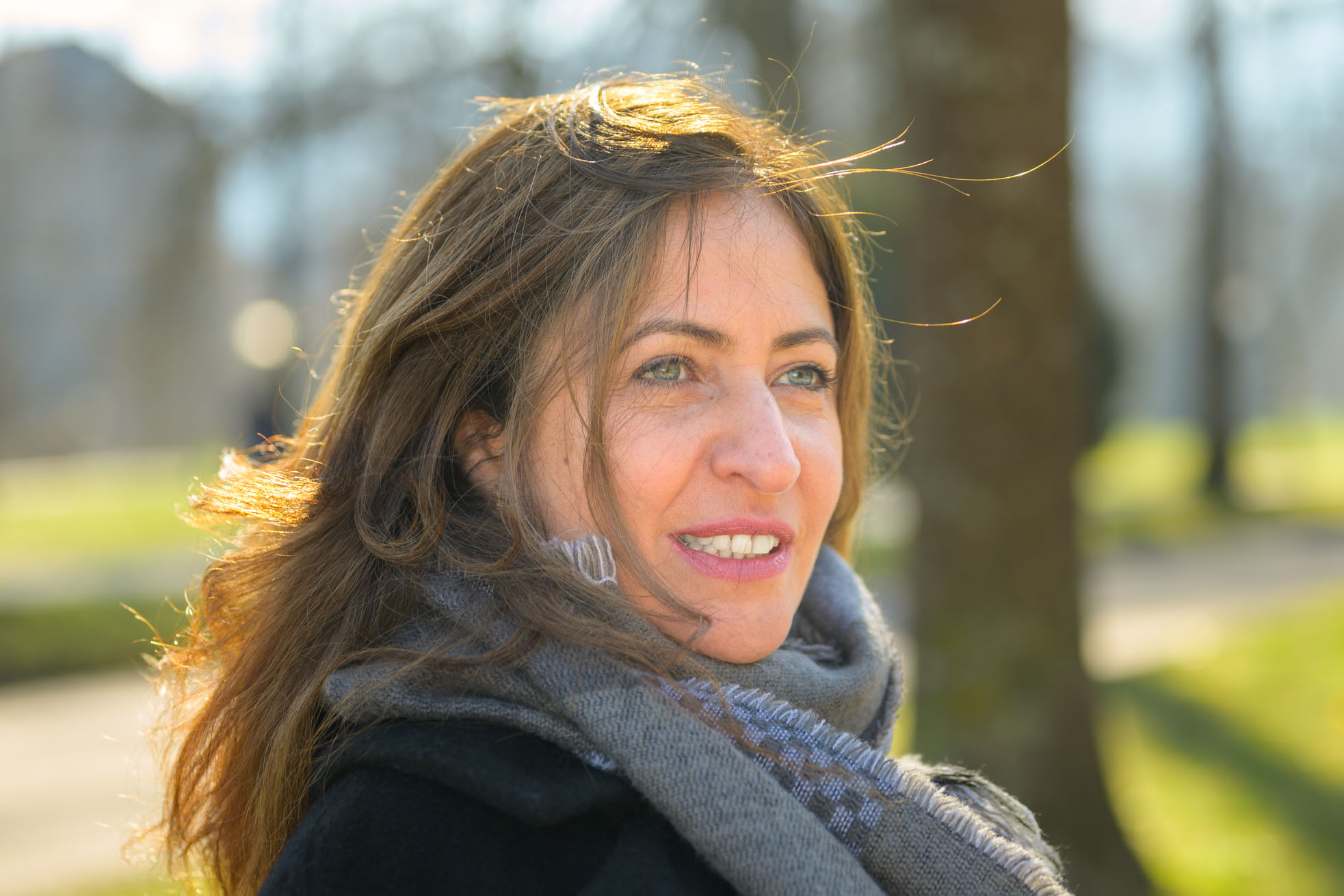 Attractive woman sitting daydreaming in a park in early spring