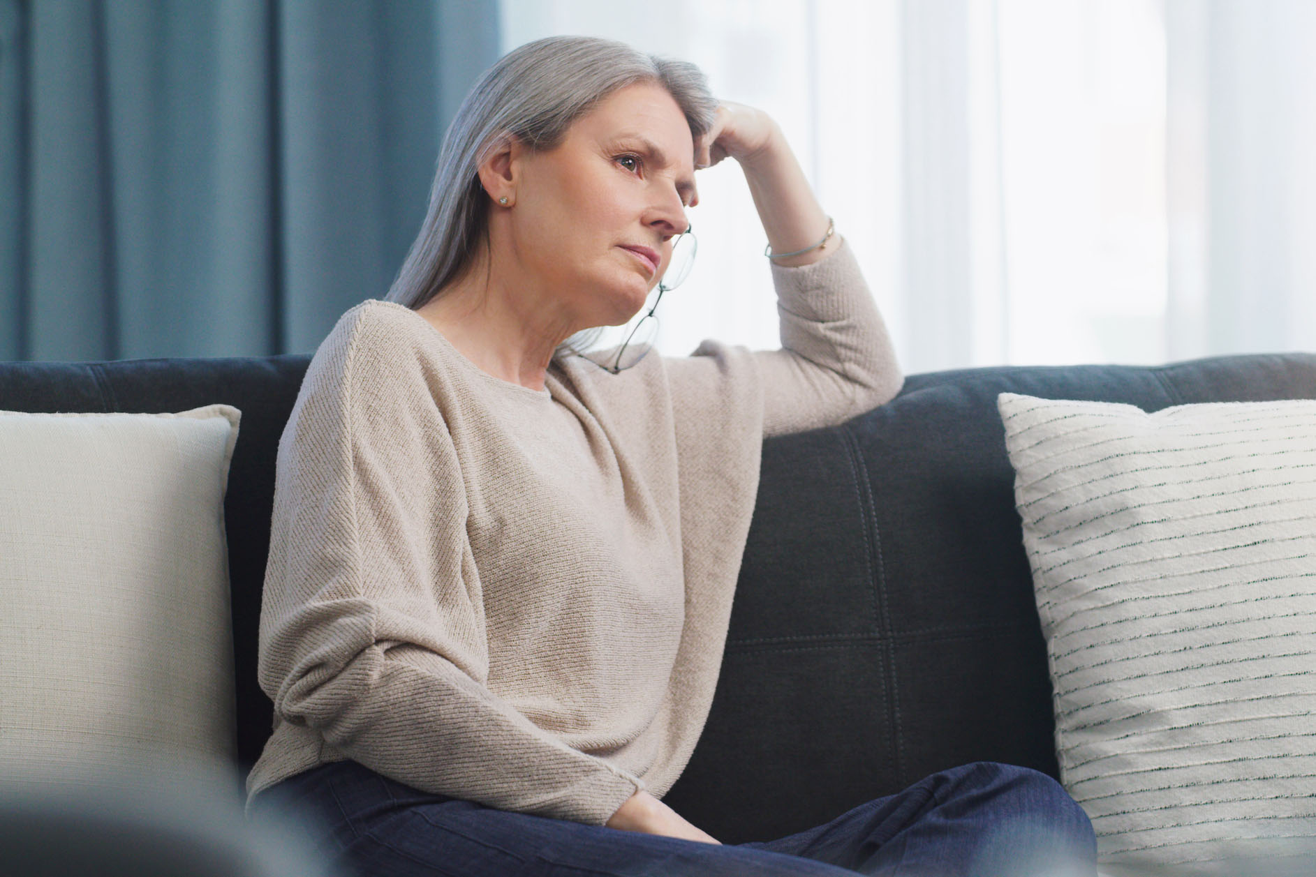 Cropped shot of an attractive senior woman looking worried while sitting on the sofa at home