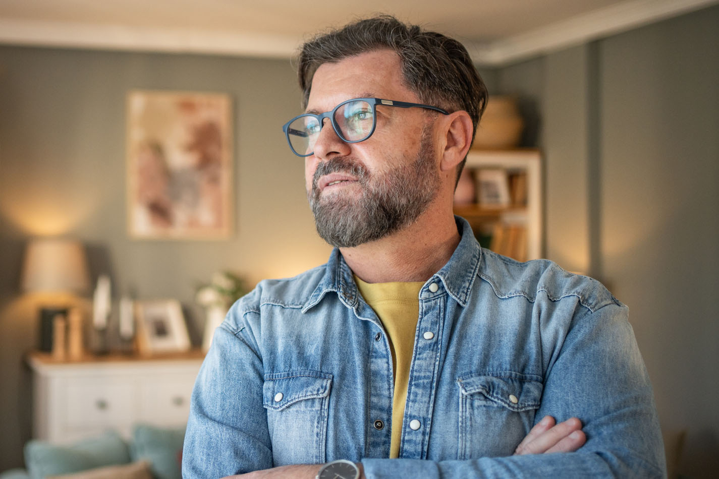 Pensive mature man contemplating in living room