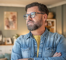 Pensive mature man contemplating in living room