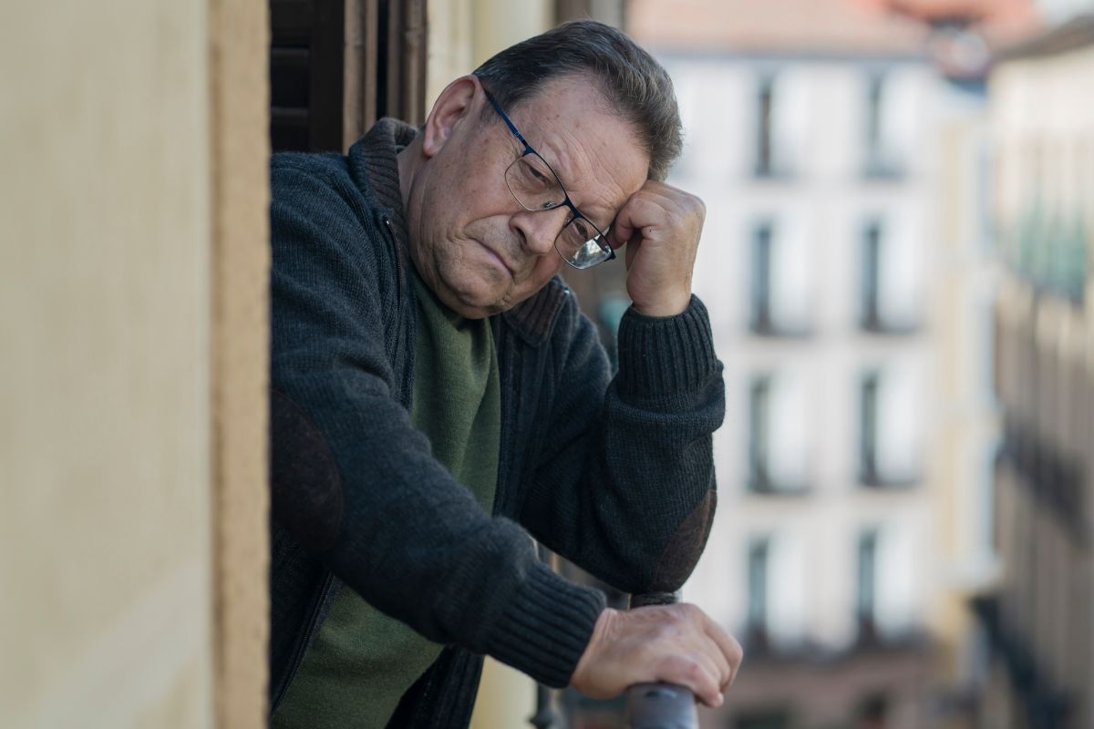 Smutny starszy mężczyzna na balkonie