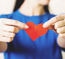 Kobieta trzymająca przerwane papierowe serca