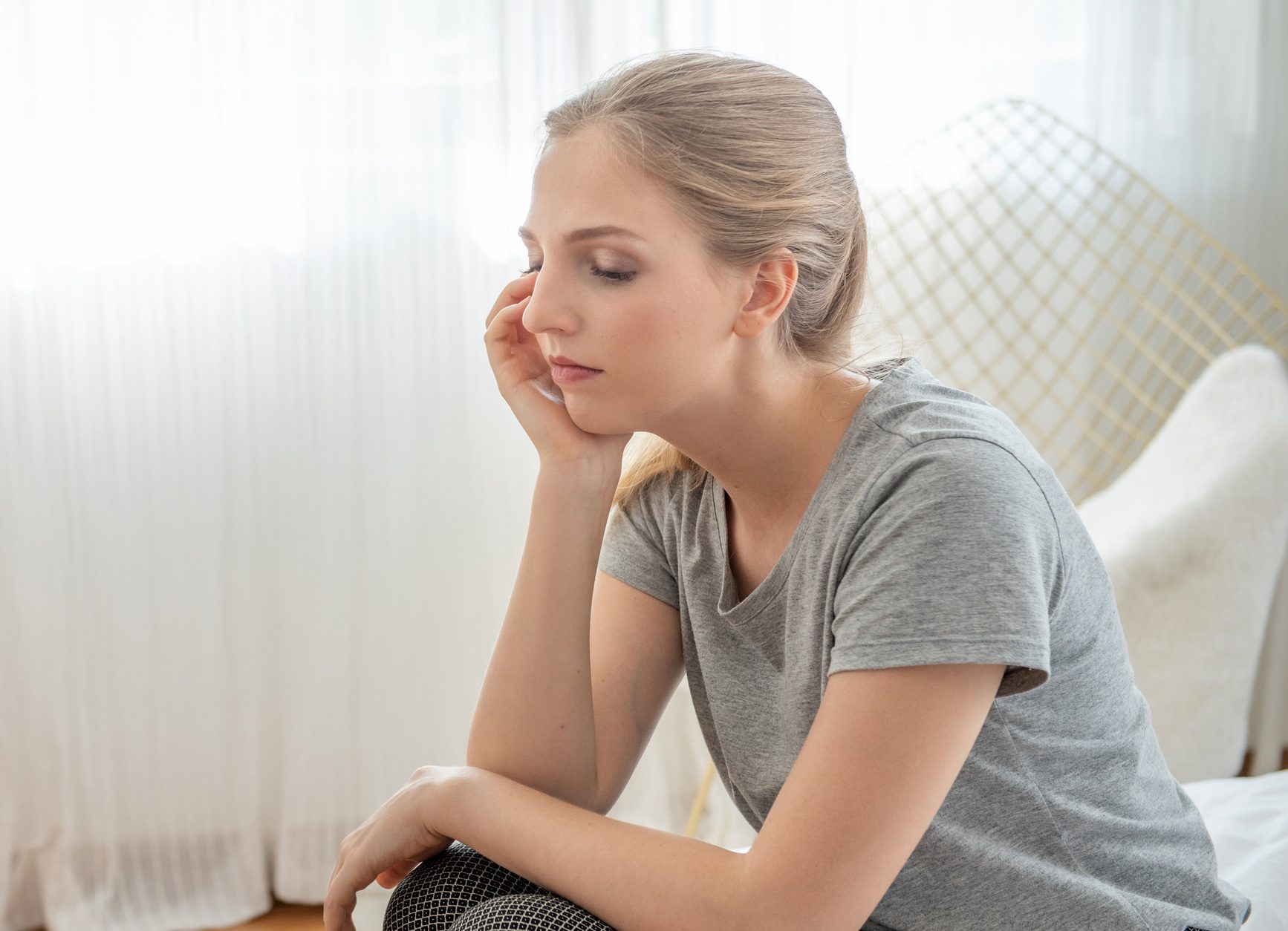 Portrait of young depressed caucasian woman dress in casual dress sit on bed with sorrow,hopeless,unhappy in trouble emotion.