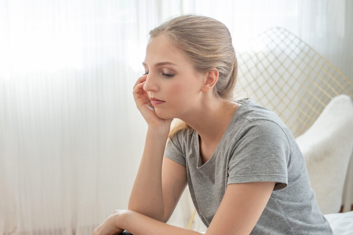 Portrait of young depressed caucasian woman dress in casual dress sit on bed with sorrow,hopeless,unhappy in trouble emotion.