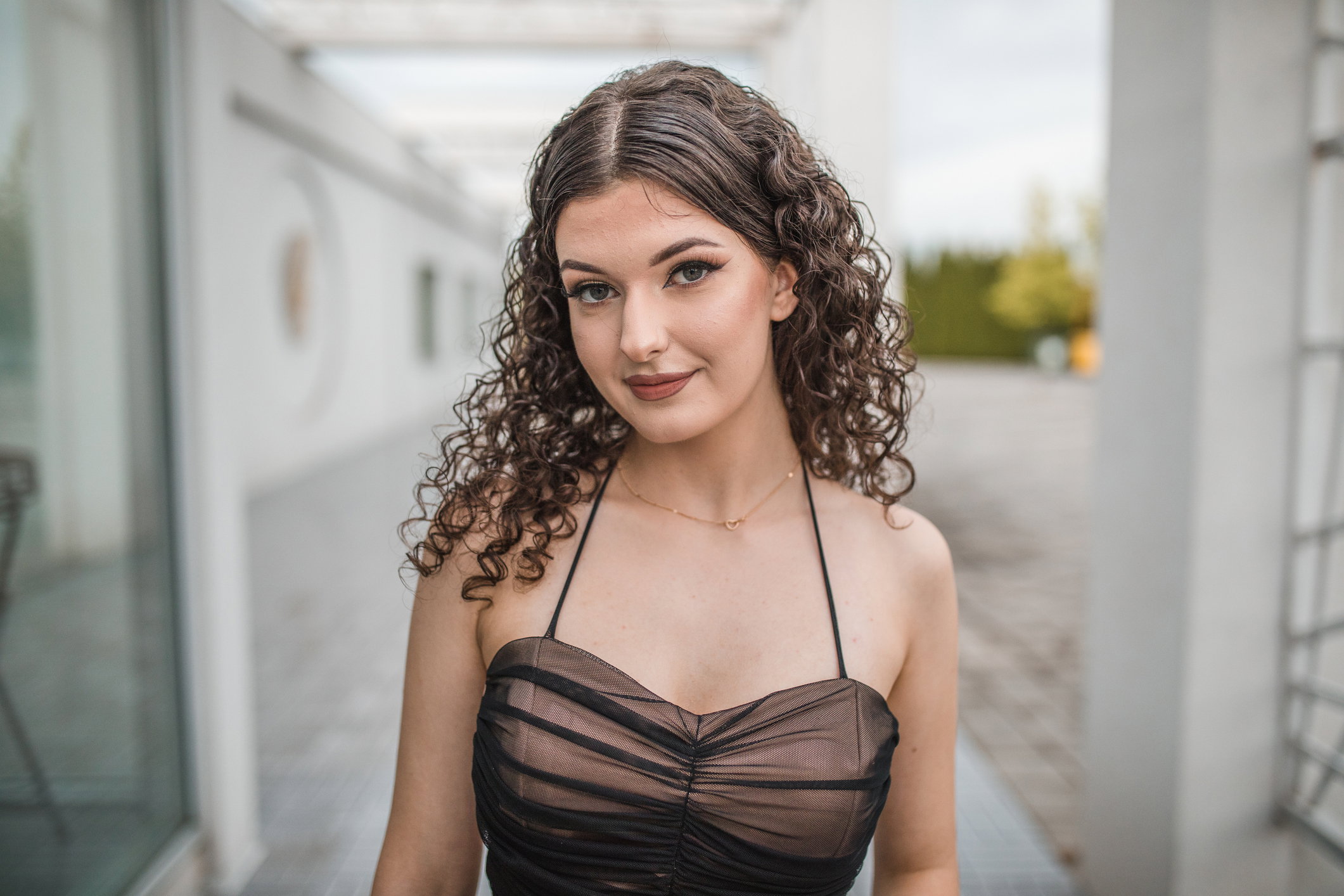 Waist up view of a beautiful young graduate girl in an elegant dress