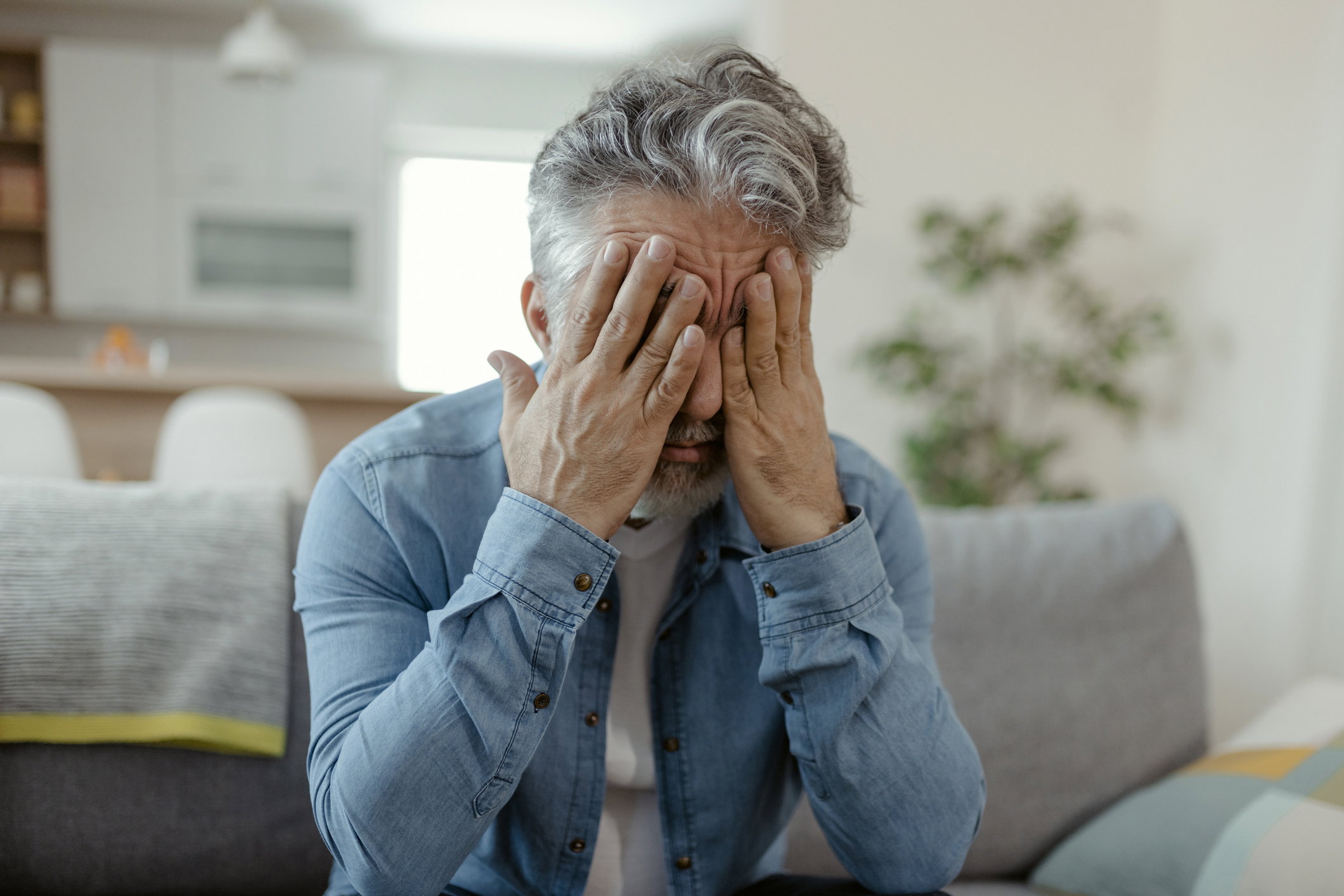 Mature Adult Man Suffering From Migraine Pain At Home