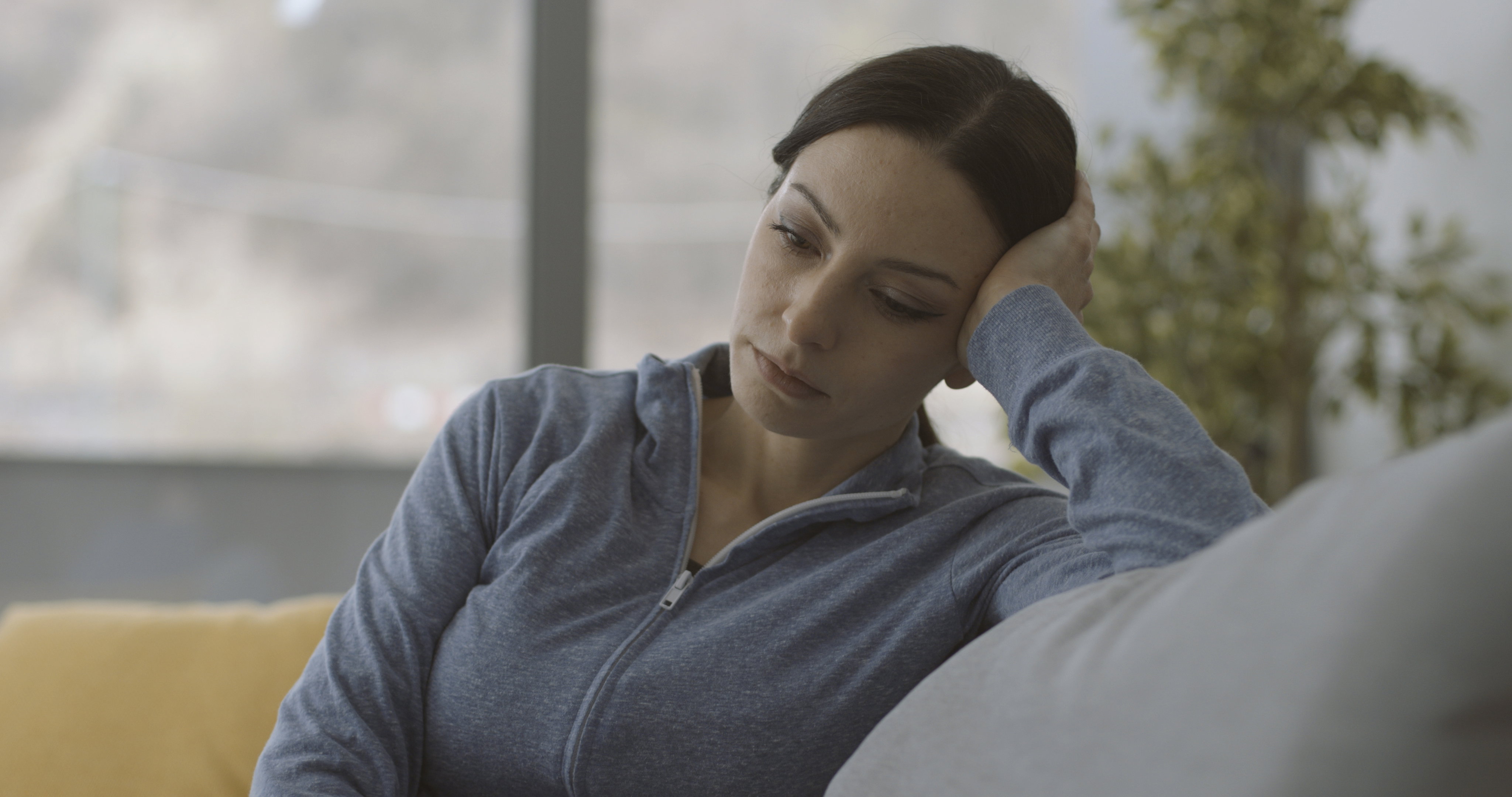 Exhausted lonely woman sitting on the couch