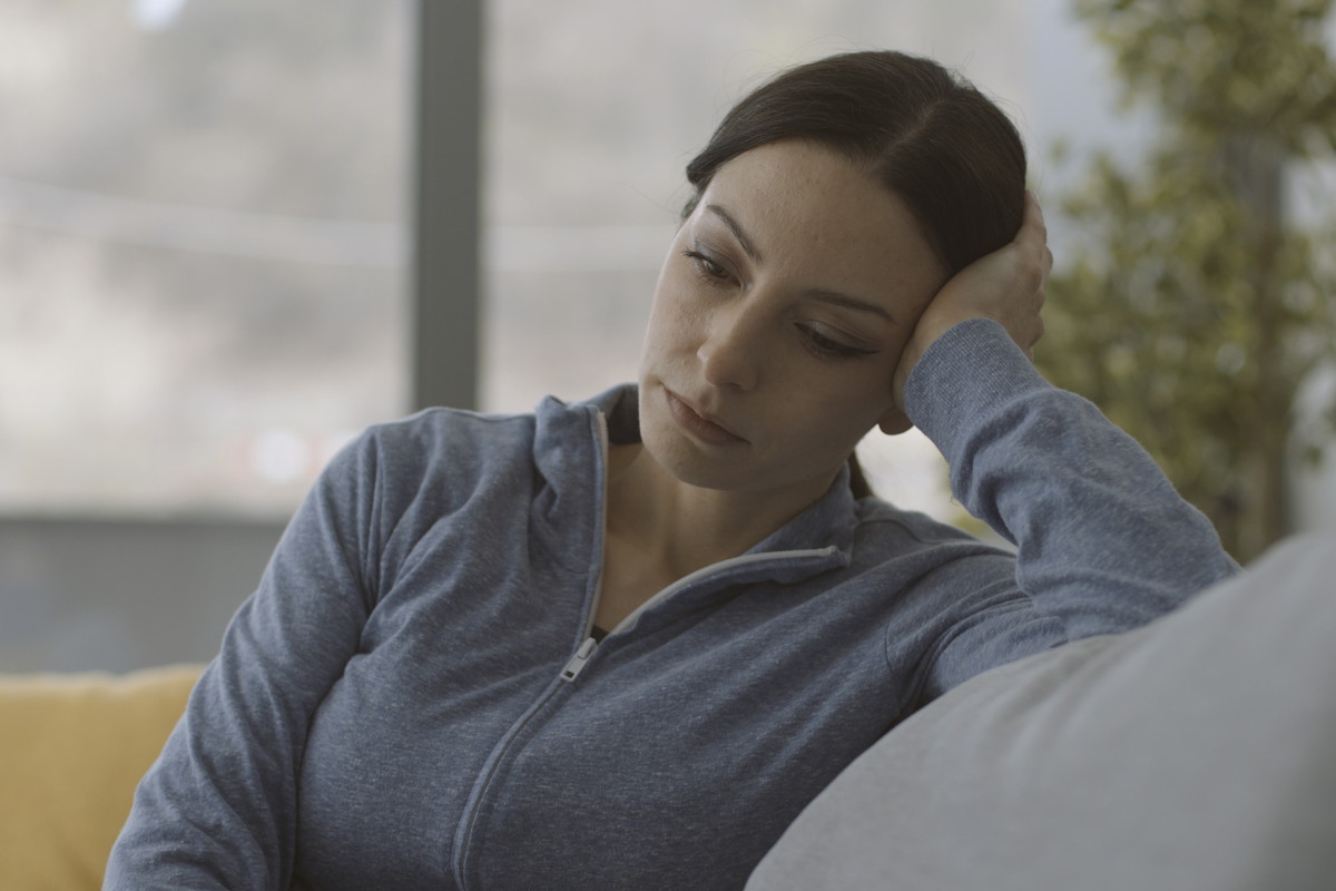 Exhausted lonely woman sitting on the couch