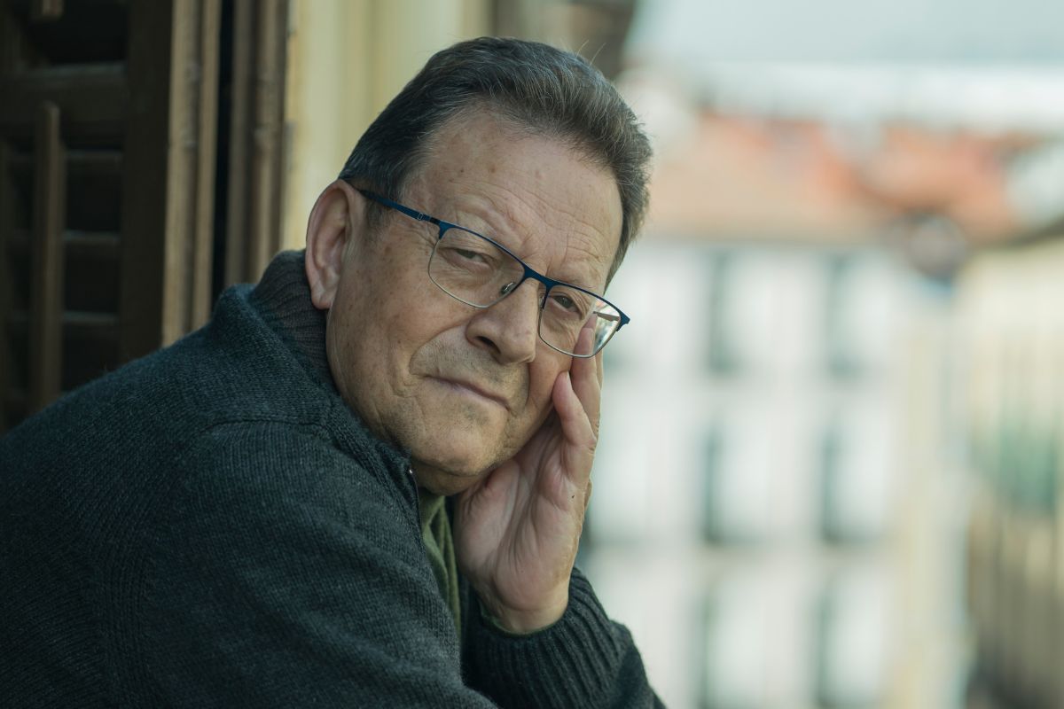 zamyślony starszy mężczyzna na balkonie