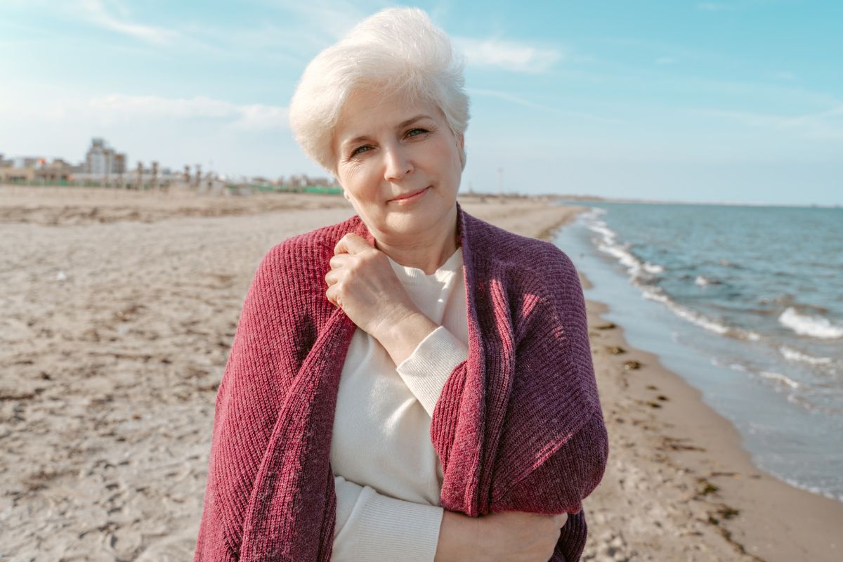 Zamyślona starsza kobieta na plaży