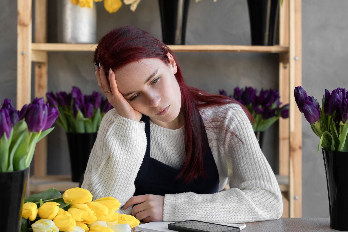 Smutna kobieta w otoczeniu tulipanów