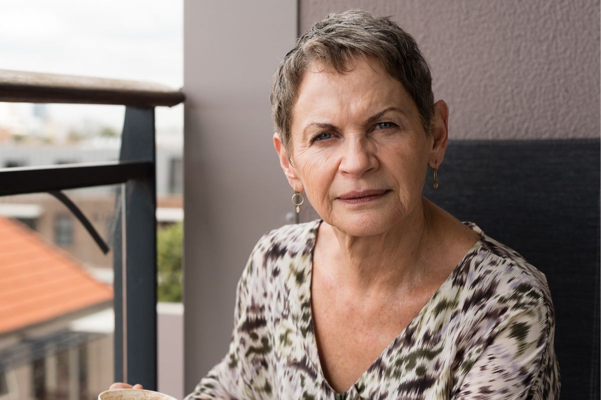 Zamyślona starsza kobieta na balkonie