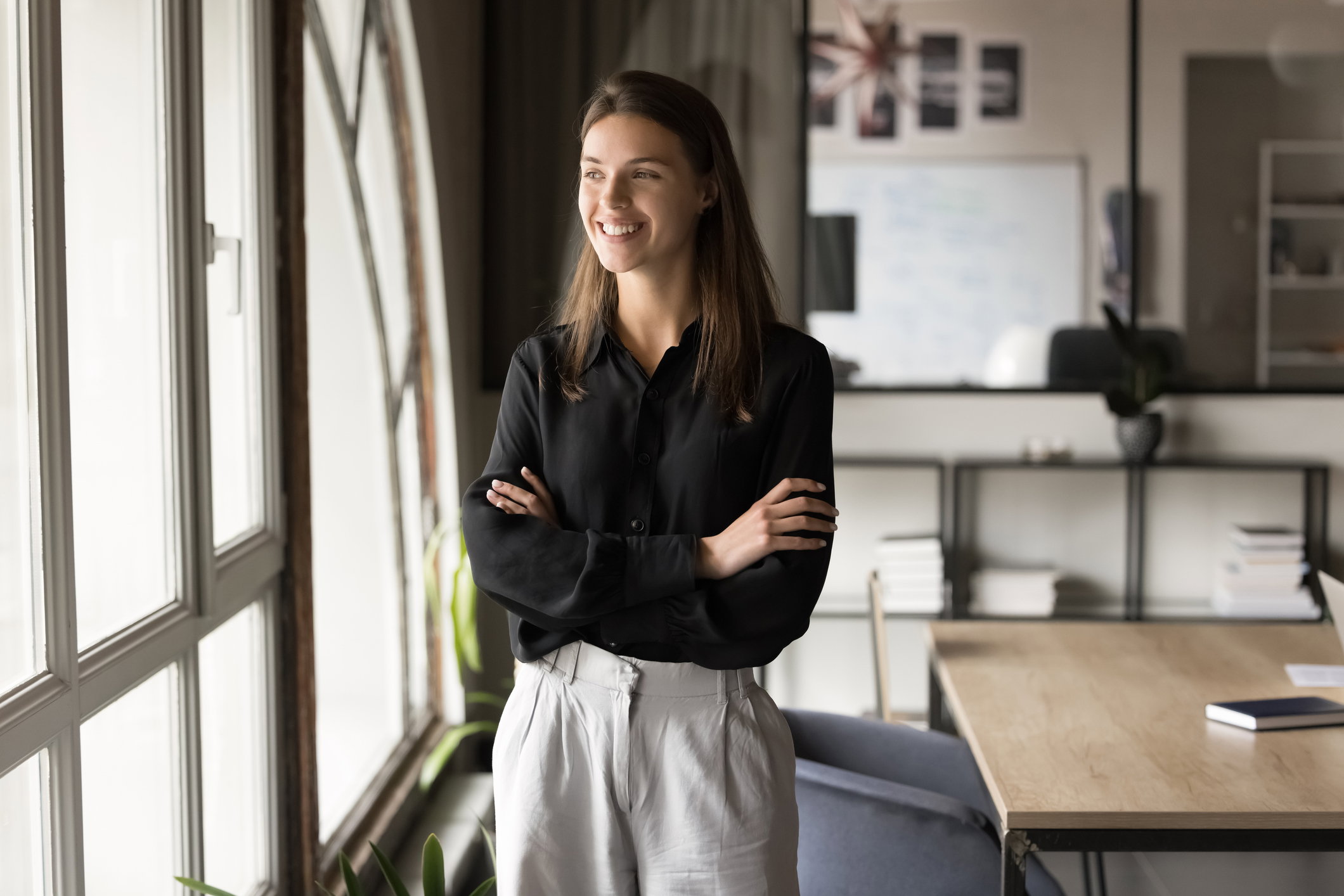Positive young manager woman in formal cloth posing in office