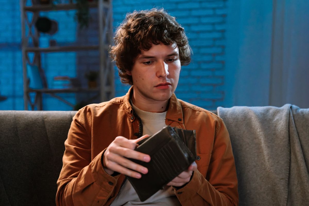 Smutny mężczyzna zagląda do portfela