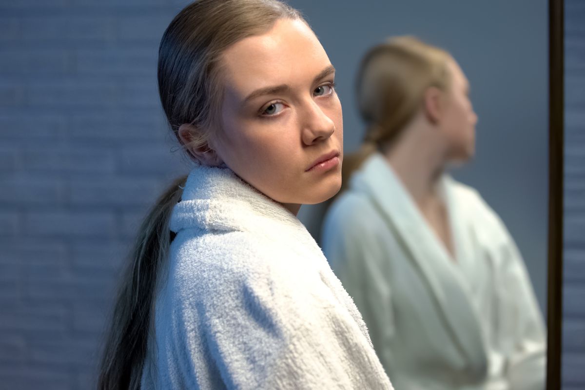 smutna kobieta i jej odbicie w lustrze