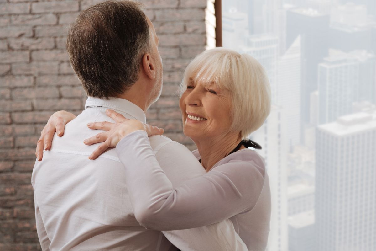 uśmiechnięta starsza kobieta tańczy z partnerem