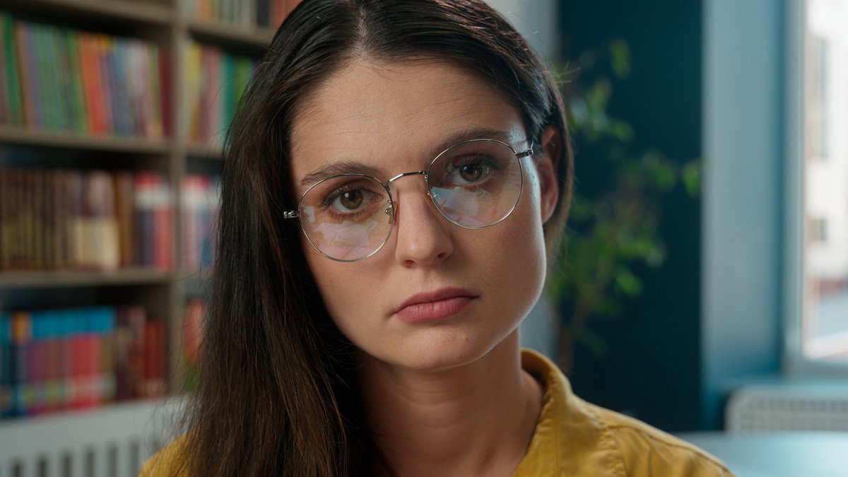 Sad worried tired exhausted girl Caucasian woman high school student teacher helpless stressful books studying learning college university library problem overwork holding text help education overload