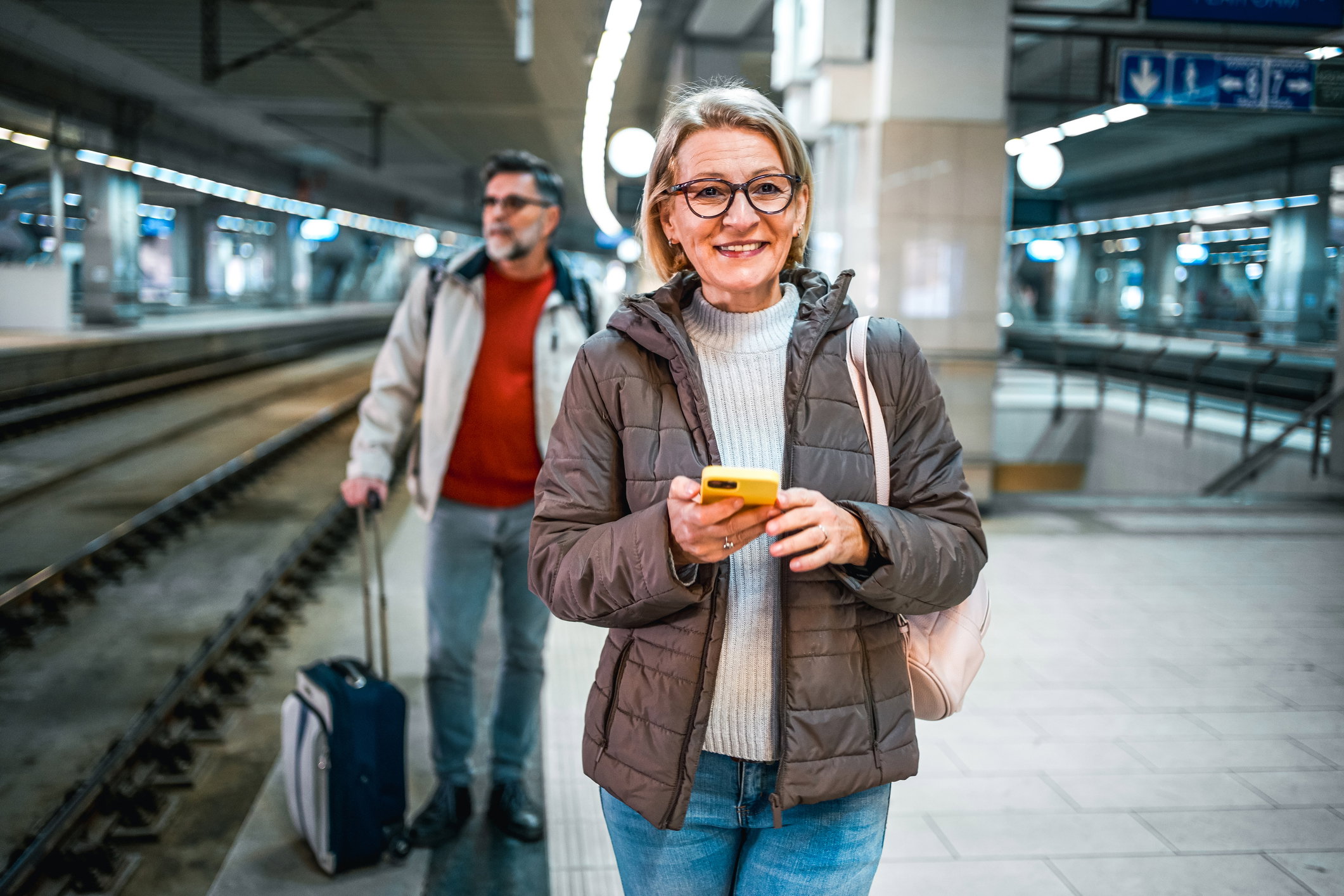 Mature woman using phone in a subway station