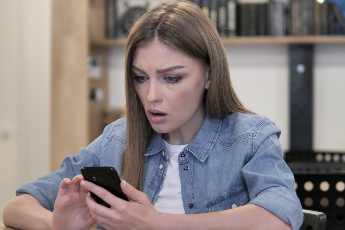 zdziwiona kobieta patrzy w telefon