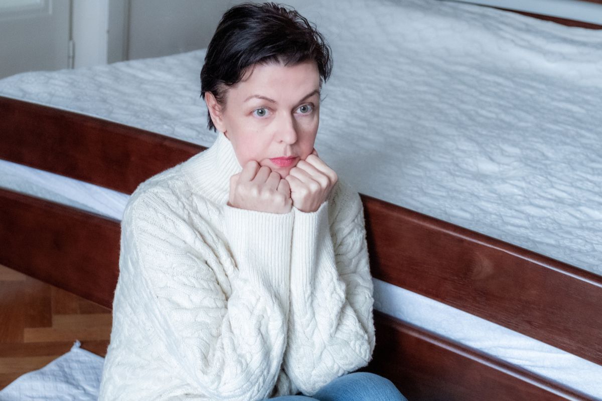 zszokowana kobieta przy łóżku
