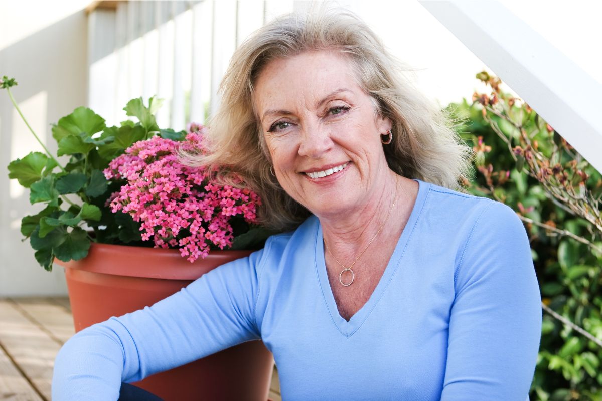 uśmiechnięta starsza kobieta na tarasie