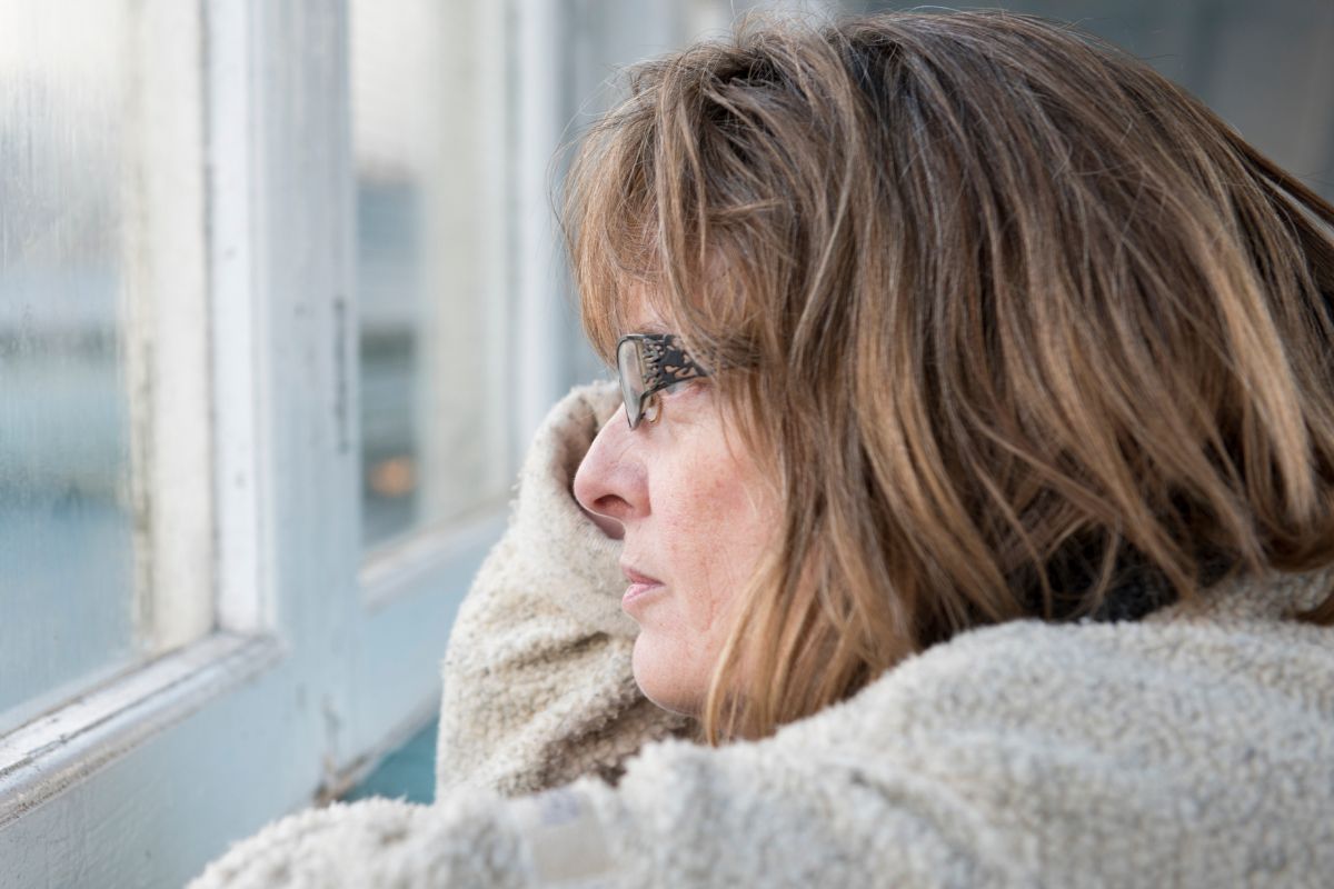 zamyślona kobieta patrzy przez okno