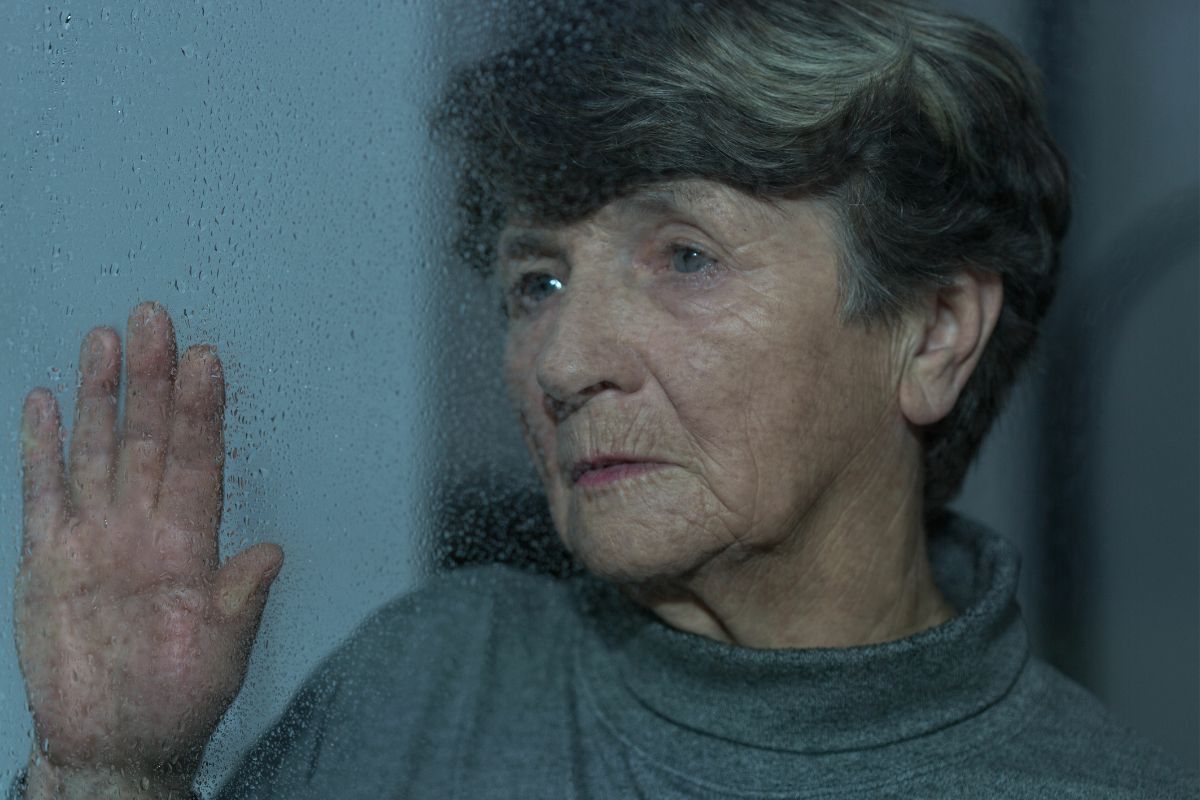 Smutna starsza kobieta w oknie