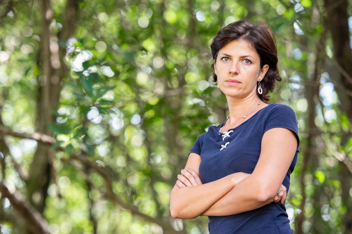 młoda kobieta ze zmartwioną miną i założonymi rękami na łonie natury