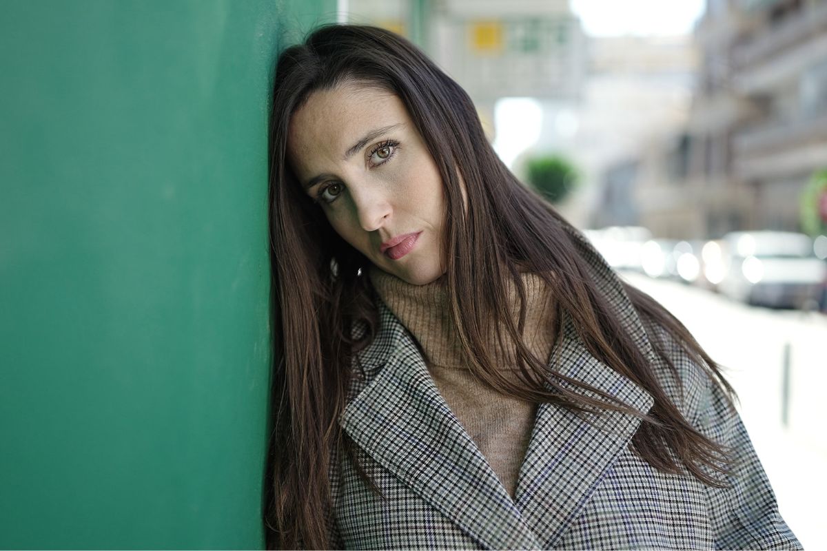 smutna kobieta na ulicy przy ścianie