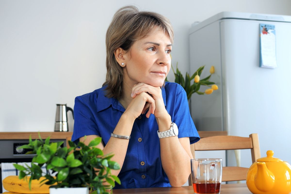 poważna kobieta siedząca przy stole