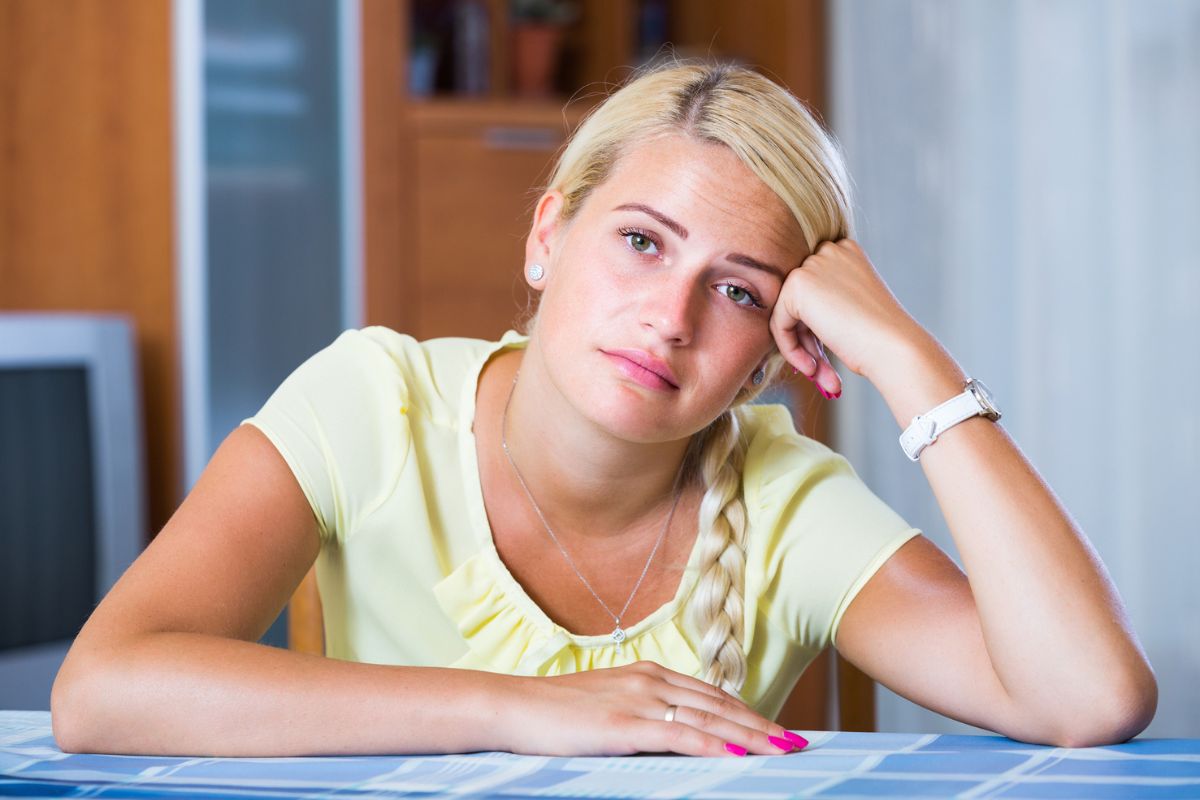 smutna kobieta opierająca się o stół