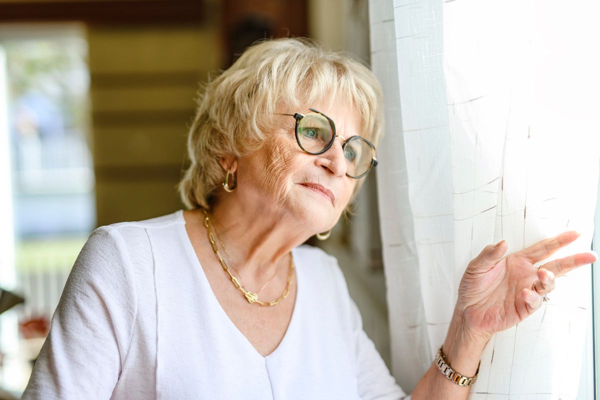 smutna kobieta patrzy przez okno